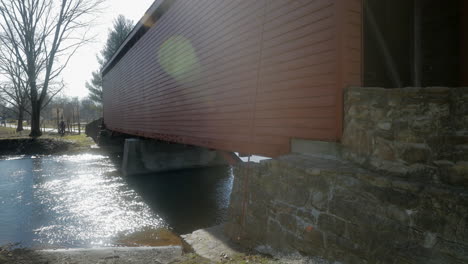 winter, static shot with sun flares of one of three covered bridges in maryland.