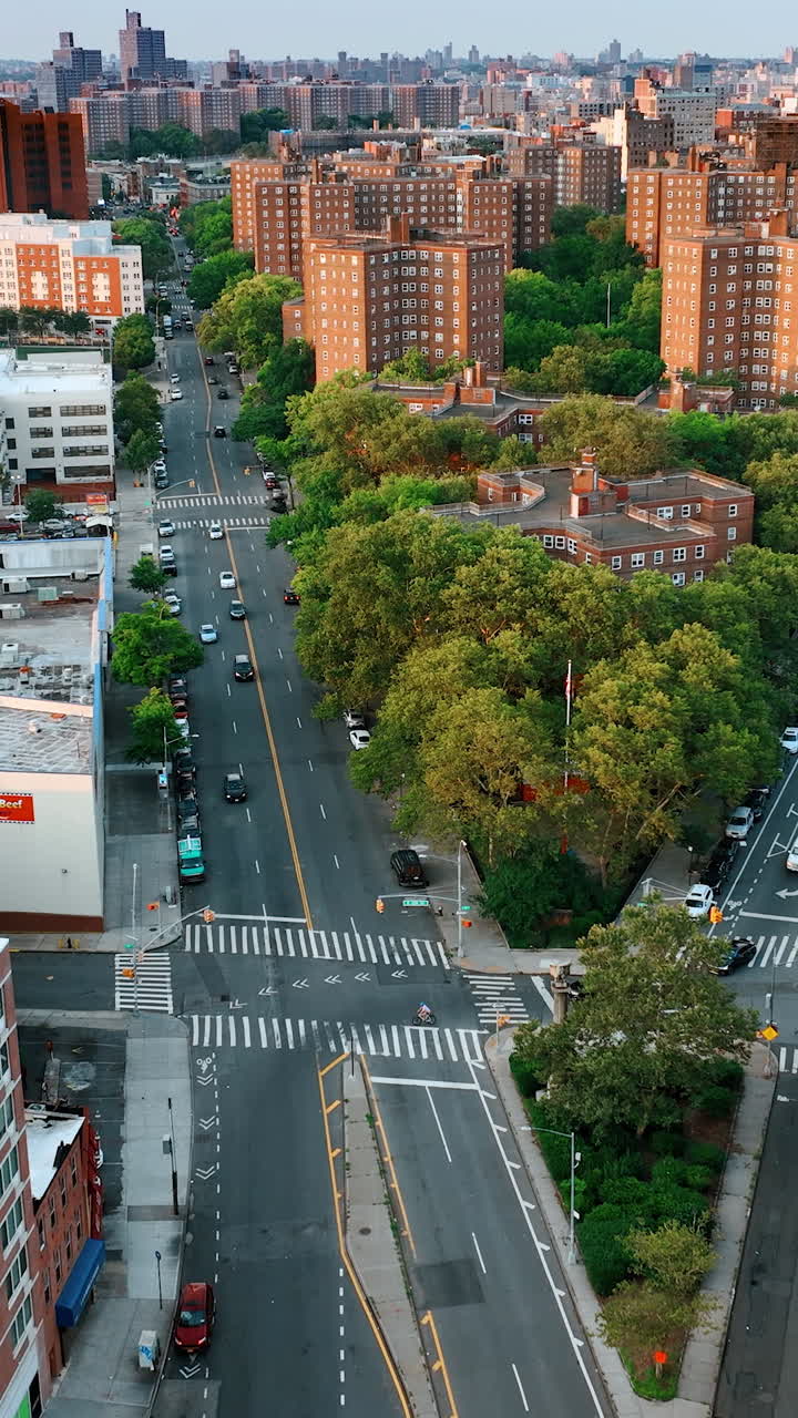 Two highways merge into one. Busy roads around the green residential area. New York cityscape from top view. Vertical video