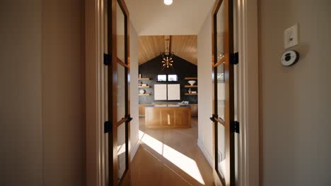a minimalist modern office with large windows, wooden ceiling, and built-in shelving, featuring a central island and natural light streaming through the windows