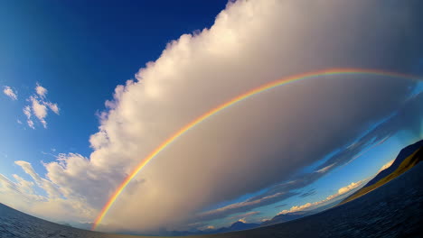stunning rainbow arching over water with expansive sky and clouds