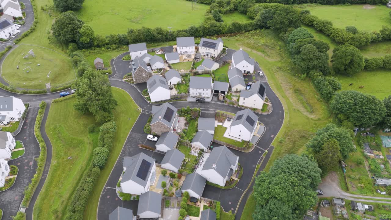 Aerial view of a picturesque smallholding of new build homes nestled within a larger modern development in the lush UK countryside