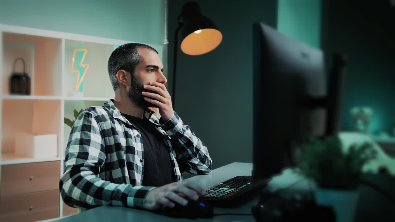 Handsome male freelancer, editor, data analyst or designer with beard working at his desk, on a modern home office studio