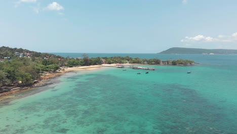 Tropical-sand-beach-of-M'pai-bay-with-rustic-wooden-jetty,-Koh-Rong-Samloem,-Cambodia