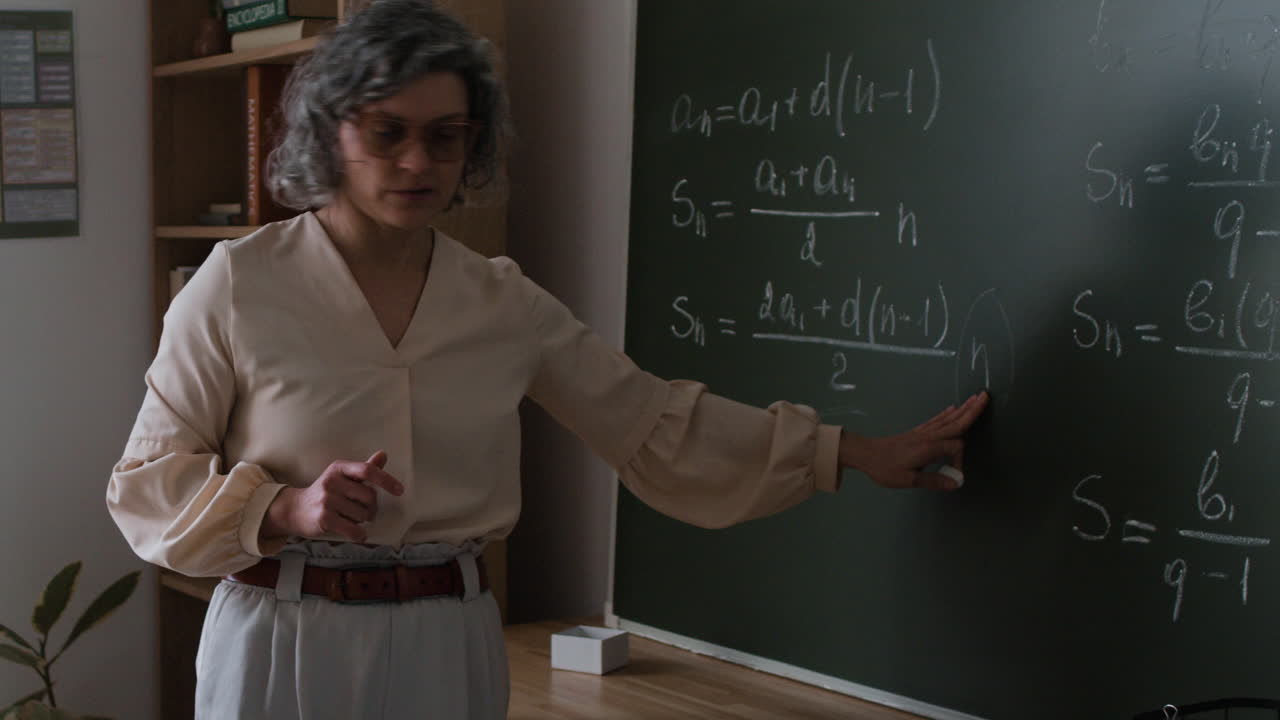 Teacher Explaining Math on a Chalkboard
