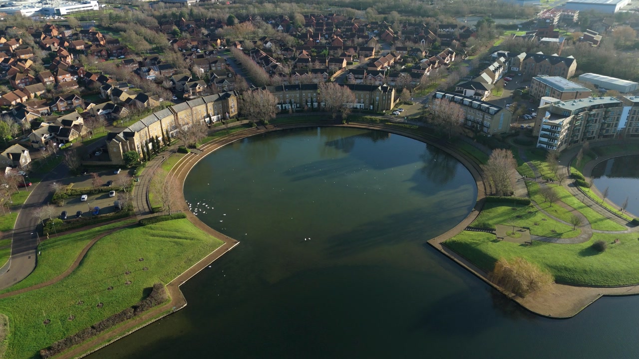 Drone view of a cold winter day at Caldecotte Lake, Milton Keynes, showing the circular bays and surrounding commercial architecture.