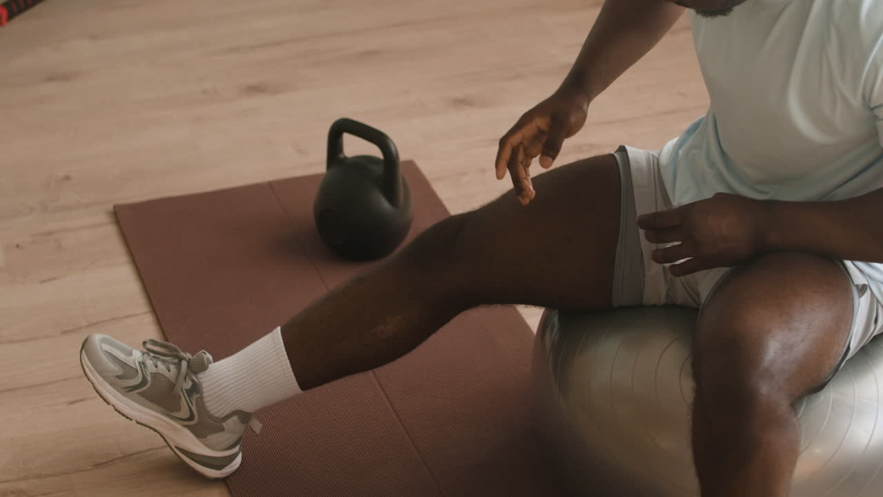 Man Exercising with Kettlebell and Exercise Ball