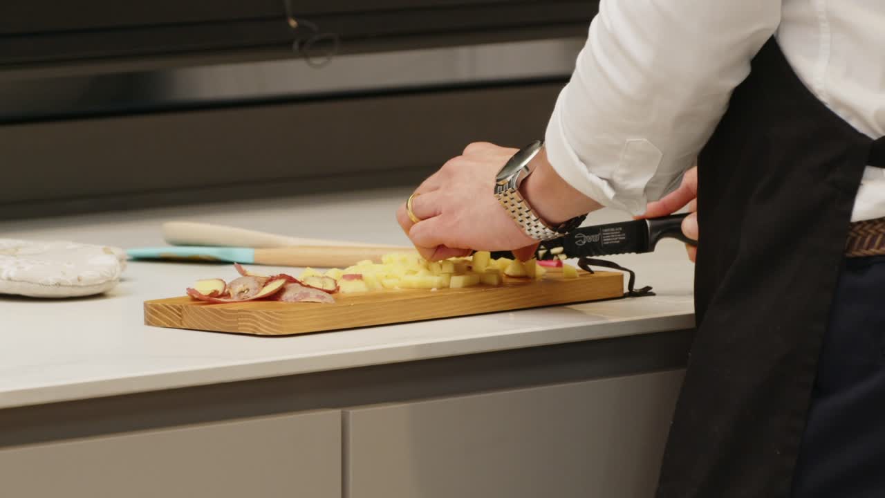 Chef prepares ingredients on a wooden board in a Portuguese kitchen setting
