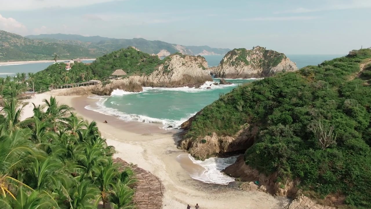 Spiaggia di Maruata Viejo e Maruata con sabbia bianca e vegetazione tropicale sulla costa del Pacifico. Dolly aereo verso il punto di riferimento Dedo de Dios.