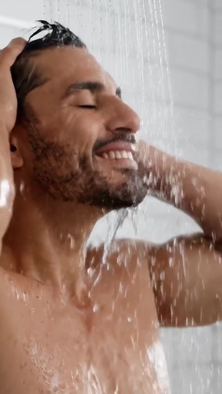 Una Experiencia de Ducha Refrescante: Emoción y Relajación Capturadas en Dos Marcos Íntimos de un Hombre Disfrutando de los Beneficios Terapéuticos del Agua Tibia y Momentos de Calma
