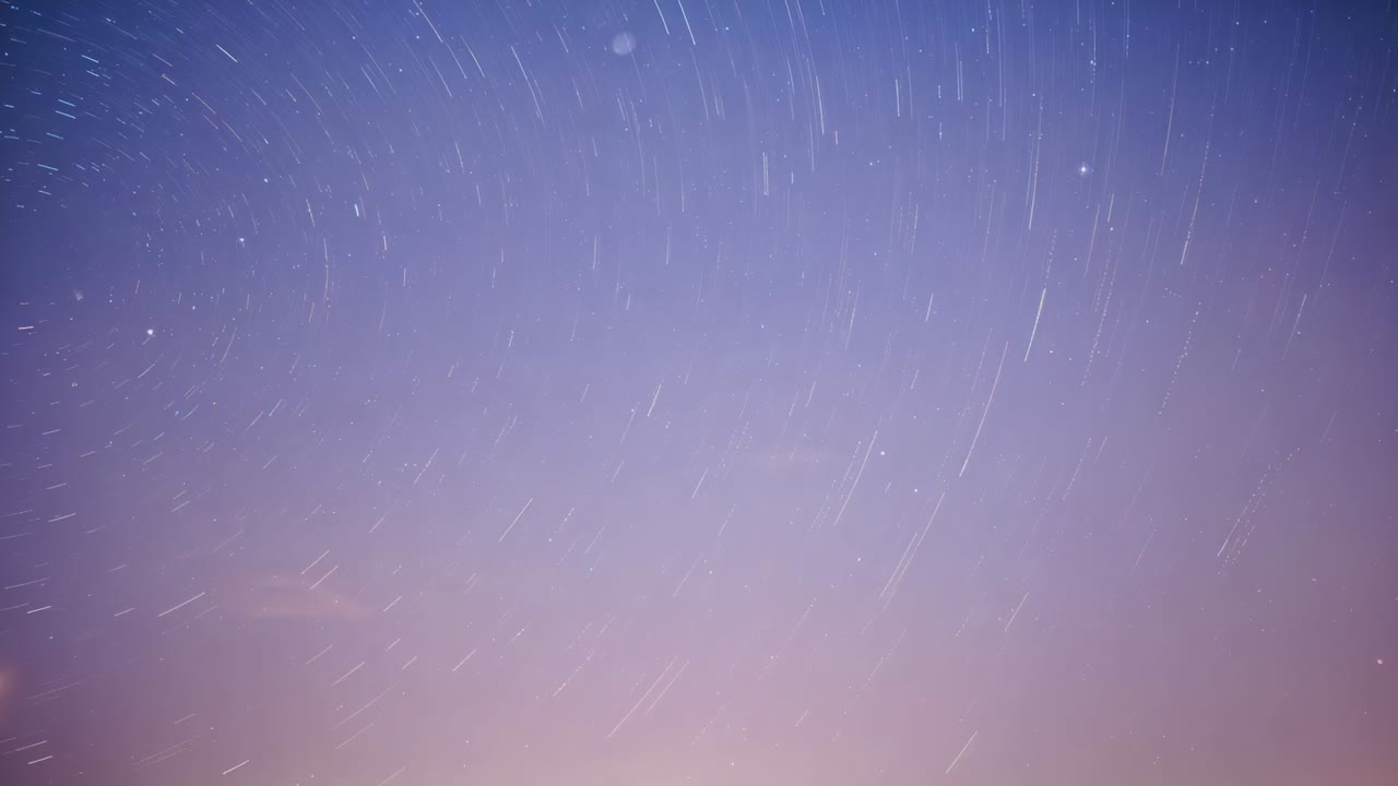 Forming circular star trails, stars lengthening arcs across stacked exposures over low horizon glow