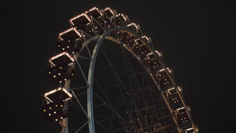 bright ferris wheel turning spinning at night at a amusement park