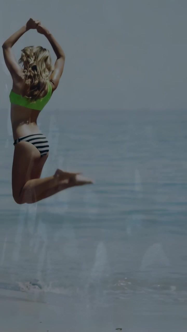 Video verticale: Donna che entra nell'acqua bassa, correndo, saltando, atterrando e camminando, per i viaggi.
