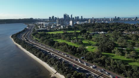 busy road along swan river and royal perth golf club with cbd in background, western australia