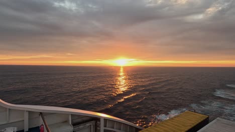 golden sunset horizon in calm ocean from deck of large transport ferry