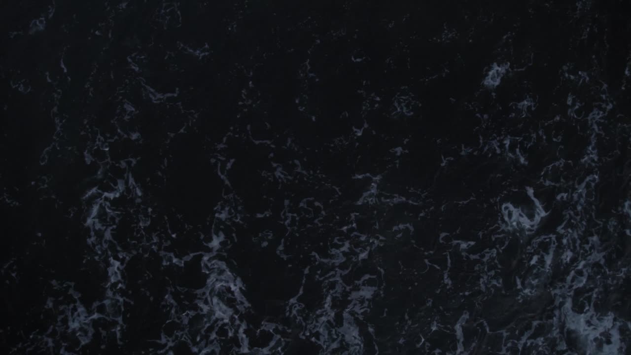 Waves crashing over dark ocean