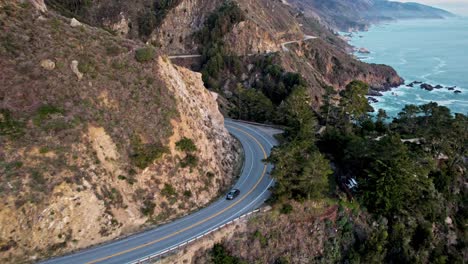epic drone view of california’s pacific coast highway winding along steep cliffs and ocean
