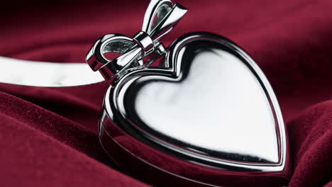 silver heart locket on red silk fabric