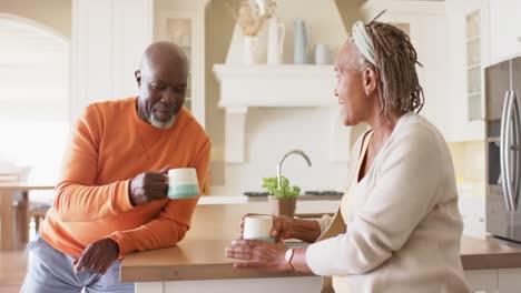 Feliz-Pareja-De-Ancianos-Afroamericanos-Tomando-Café-En-La-Cocina,-Cámara-Lenta