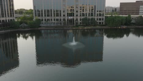 selective focus on fountain on lake in front of centennial lakes office park at edina, usa. aerial.