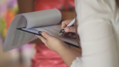 closeup woman planner hands working completing wedding checklist