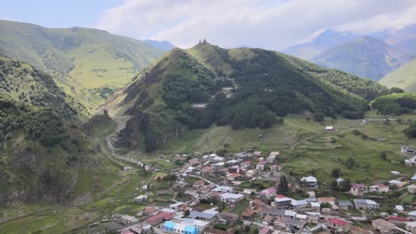 una pequeña ciudad ubicada en un valle exuberante con montañas en el fondo