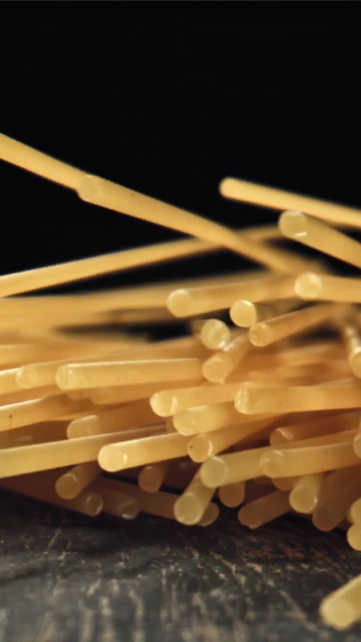 Primo piano di spaghetti crudi che cadono al rallentatore
