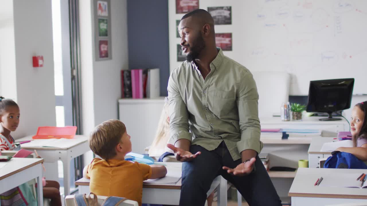 video de un feliz maestro afroamericano durante la lección con una clase de alumnos diversos