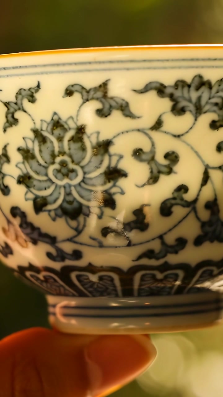 Vertikal video: Hånd som kommer inn og holder en roterende skål med fot som viser et blått blomsterbånd i varmt lys