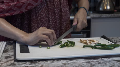 Manos-De-Mujeres-De-Minorías-étnicas-Cortando-Chiles-Verdes-Frescos-En-Una-Tabla