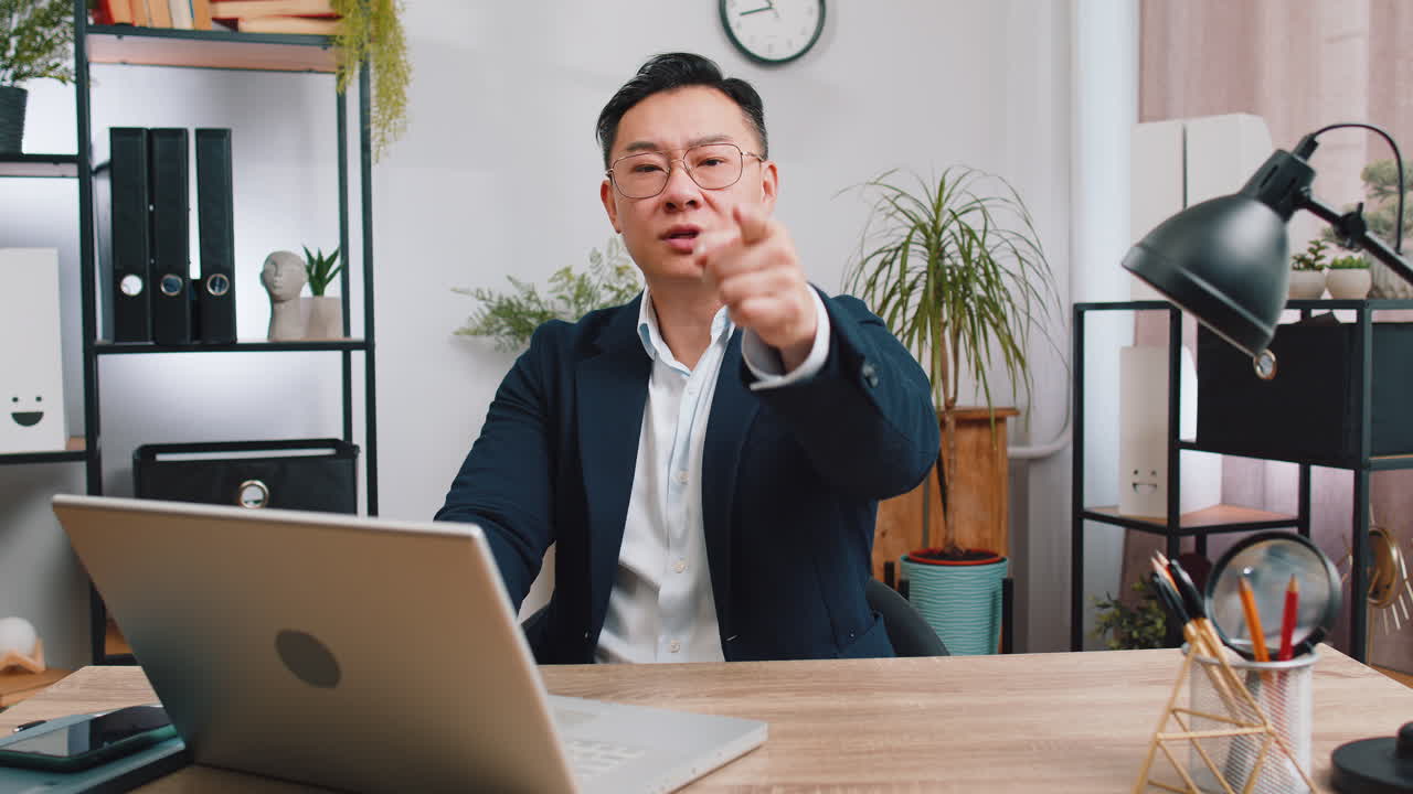 사무실 노트북 에서 일 하는 사업가 가 행복 한 표정 으로 카메라 를 가리키며 선택 을 하고 있다