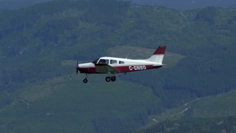 air to air view of airplane flying over mountainous terrain, sunny day