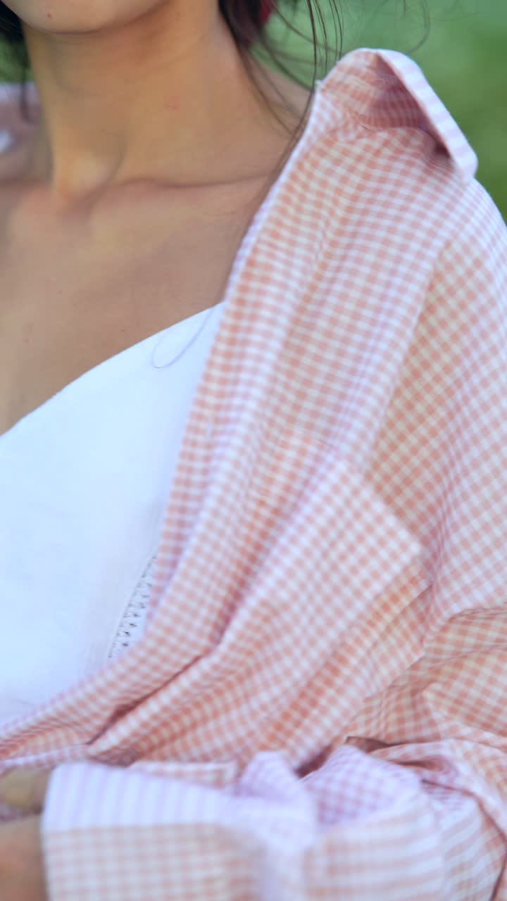 드레스 위에 분홍색과 색 체커드 셔츠를 입은 여자