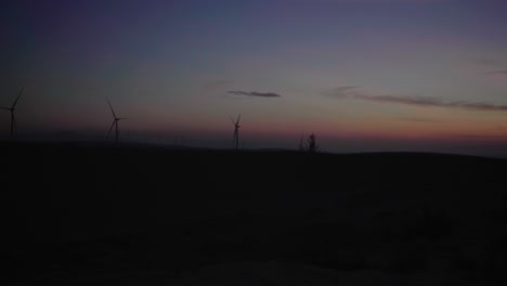 windmills at sunrise along the white sand dunes in mui ne, phan thiet, vietnam