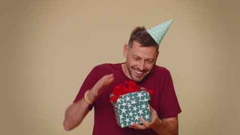 hombre sonriente recibiendo caja de regalos, asombrado satisfecho con un buen regalo, sorpresa de cumpleaños inesperada