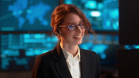 una mujer de negocios en el trabajo hablando a través de sus auriculares bluetooth, en una industria de tipo servicio al cliente, teniendo una conversación amistosa