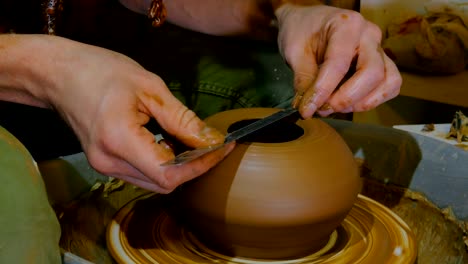 professional potter shaping bowl with special tool in pottery workshop