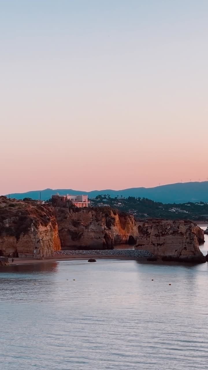 Tramonto sulla costa del Portogallo con barche in acqua
