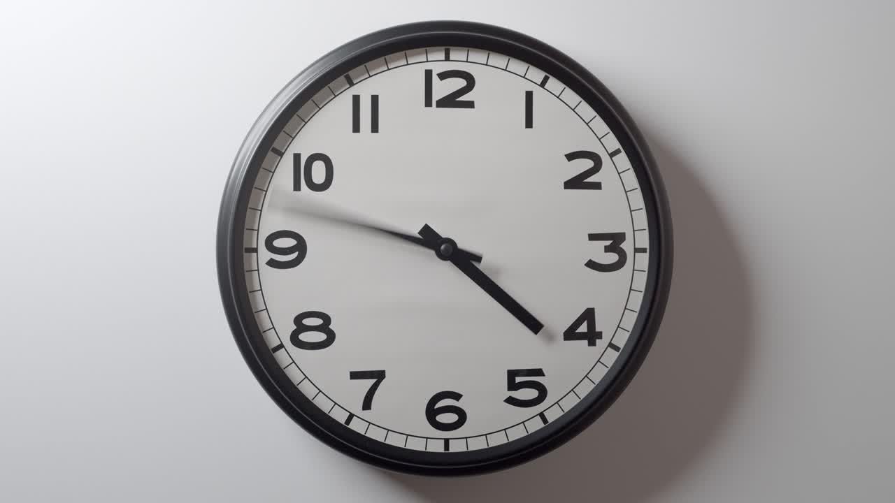 Clock Face full circle rotation 12 hours on white wall in time lapse