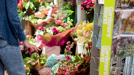 person selecting flowers at a market stall