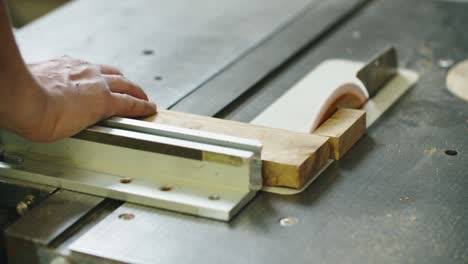 carpenter engaged in his work. wood cutting on the machine. male hands close up