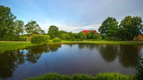 time lapse of natural lake during cloudy day with colorful leaves of trees in autumn - blue hour and beautiful landscape in park - reflection of trees on water surface