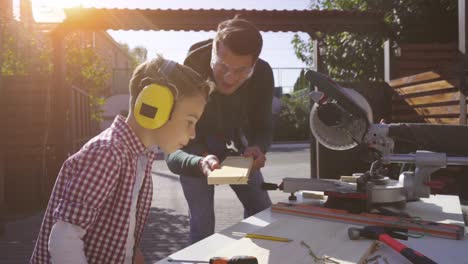 the father and son doing carpentry together. slow motion