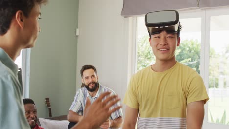 행복한 다양한 남성 친구들이 vr 헤드 ⁇ 을 사용하고 거실에서 이야기하고 있습니다.