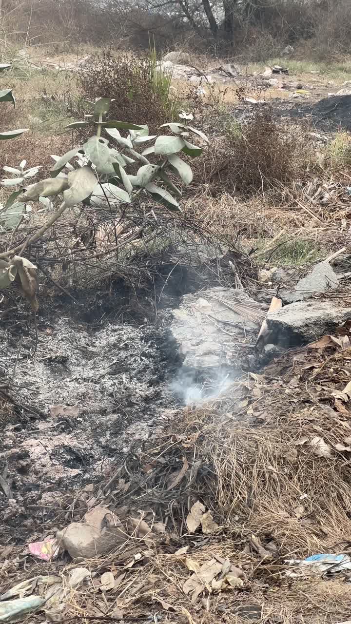 Smoke Smouldering From A Fire Pit At A Waste Landfill Disposal Site In Pakistan, Vertical Shot.