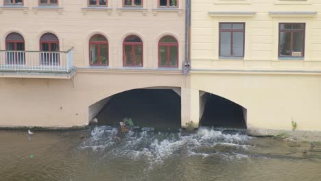 a detailed view of flooding impacting a city with water flow visibly affecting the area beneath a. a detailed view of flooding impacting a city, with water flow visibly affecting the area beneath a large building