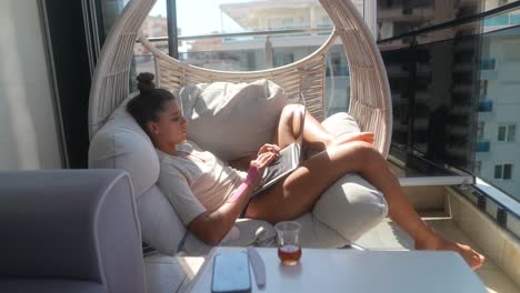 woman working on laptop on a balcony