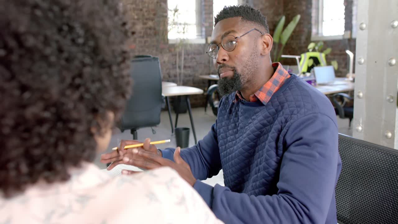 Focused diverse colleagues discussing work at table in slow motion