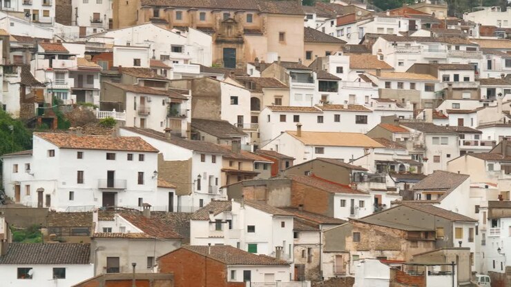 Panoramica della telecamera sull'intero villaggio di Chulilla, con piccole case tradizionali spagnole bianche sul fianco della montagna.