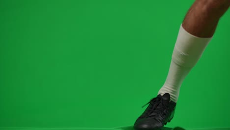 joven confiado deportista profesional caucásico huyendo con la pelota de fútbol en la plantilla de fondo chromakey.