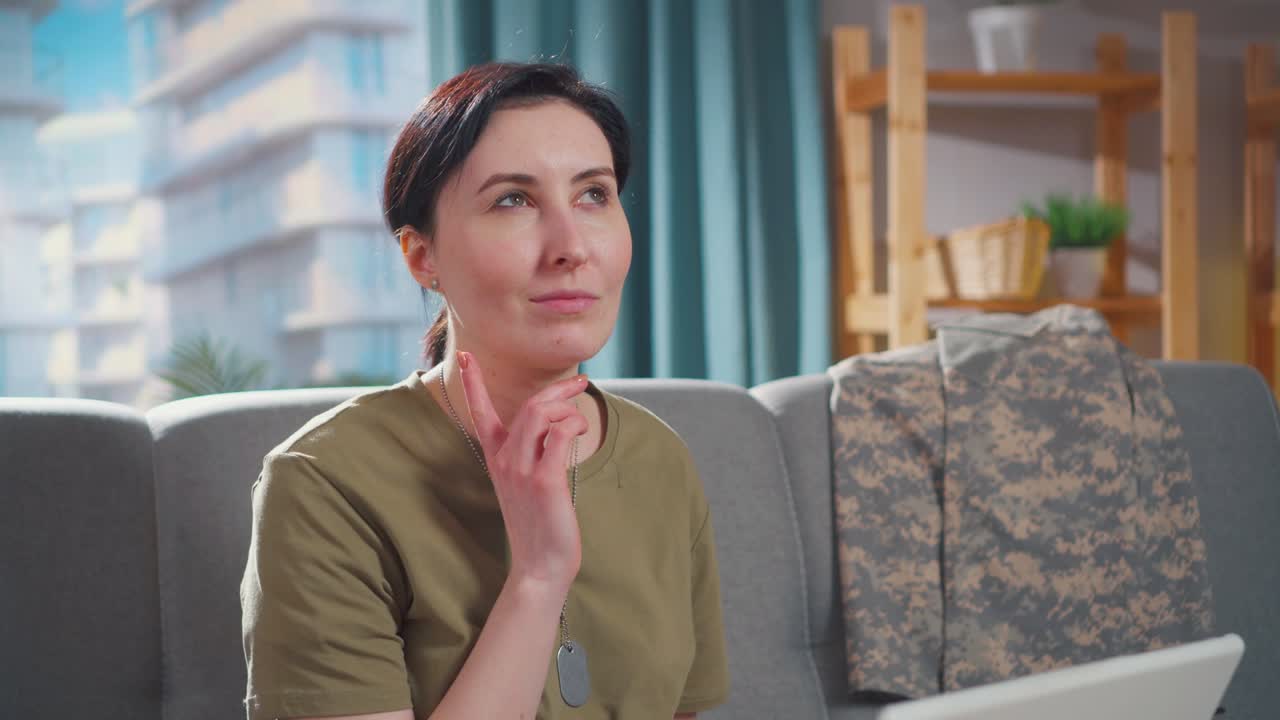 mujer joven pensativa trabajando en una computadora portátil en su apartamento